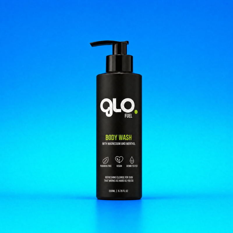 A black pump bottle of GLO Fuel Body Wash with white and green text, centered on a bright blue gradient background.